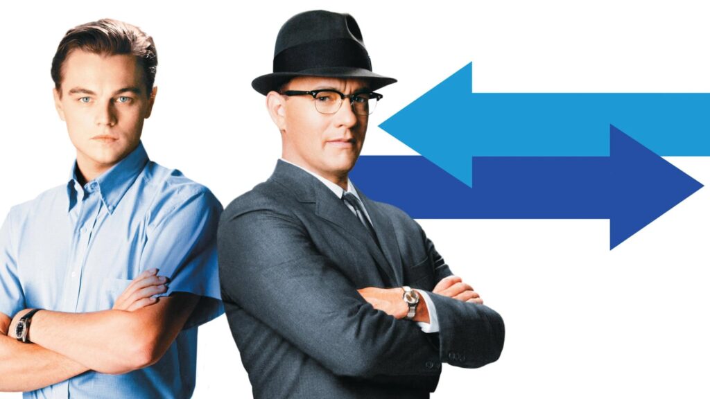 Two men stand with folded arms against a white background, with large blue arrows pointing in opposite directions behind them.