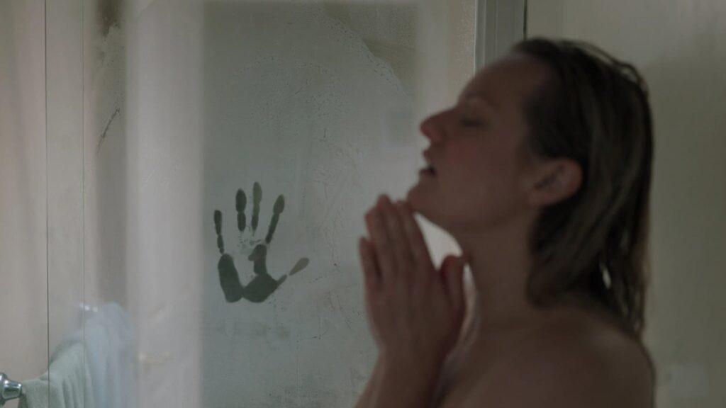 A distressed woman seen in profile behind a fogged shower door, with a dark handprint pressed into the condensation beside her.